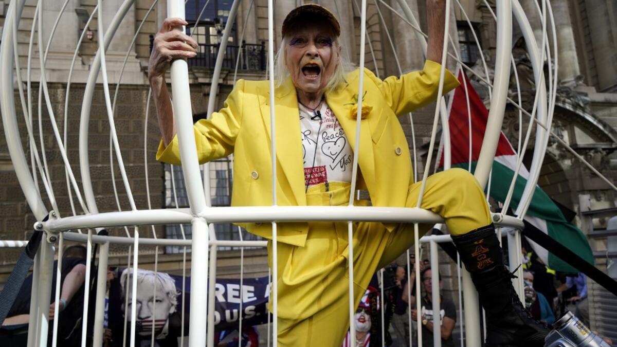 In this file photo taken on July 21, 2020 British designer Vivienne Westwood gestures from inside a giant bird-cage, suspended off the ground, in front Of the Old Bailey in central London on July 21, 2020, in protest of the extradition trial of Wikileaks founder Julian Assange. The legal controversies surrounding the WikiLeaks founder Julian Assange are now in their second decade and the divisions between his supporters and critics remain as intractable as ever. Niklas HALLE'N / AFP