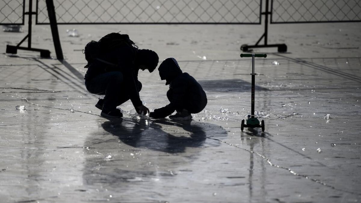 People gather on the frozen Lake Houhai in Beijing on January 7, 2021, after China's meteorological authority recently issued a severe weather warning across large parts of the country. NOEL CELIS / AFP