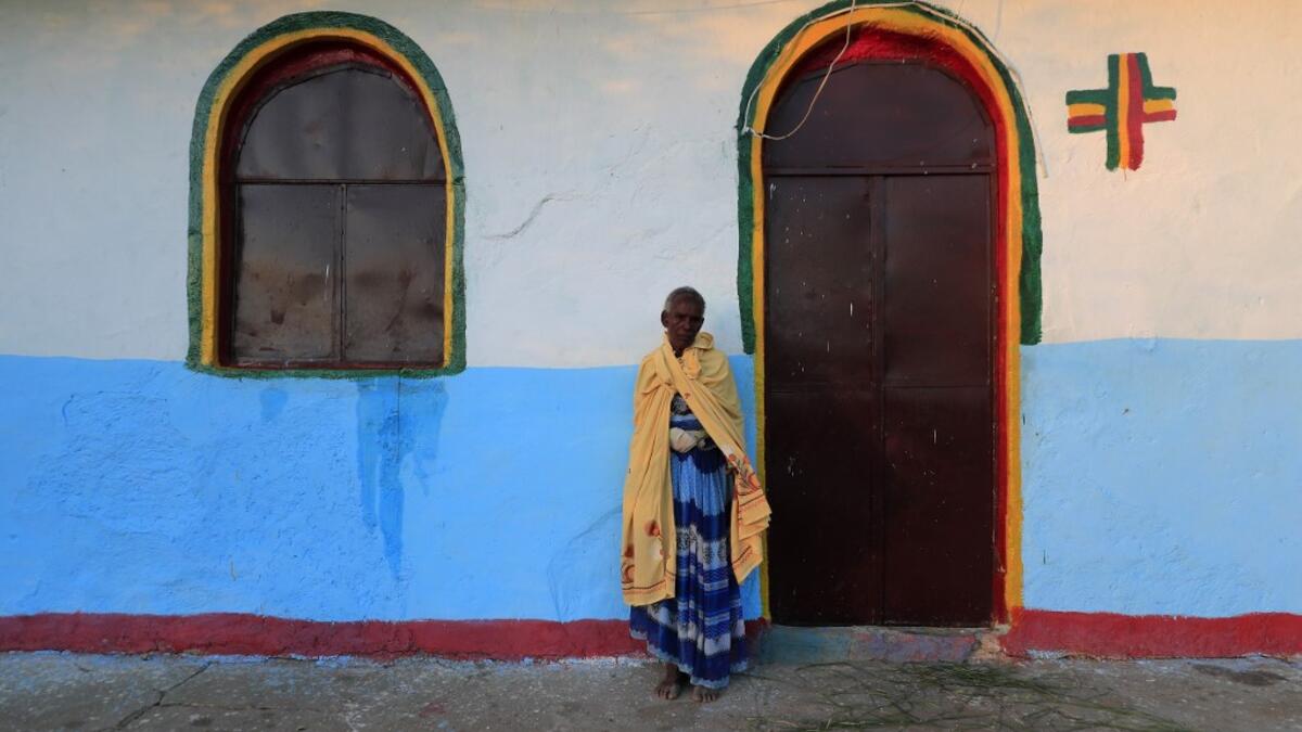 An Ethiopian refugee who fled the Tigray conflict stands outside an Orthodox church built by former Ethiopian refugees, on Coptic Christmas day at a village next to Um Raquba refugee camp in Gedaref, eastern Sudan, on January 6, 2021. ASHRAF SHAZLY / AFP