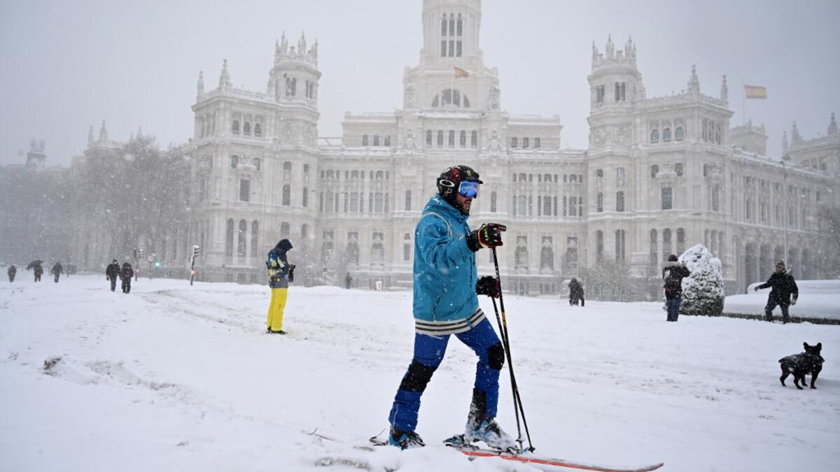 A man skis in Cibeles square amid a heavy snowfall in Madrid on January 9, 2021. Heavy snow fell across much of Spain, leaving huge areas blanketed in white as Storm Filomena brought wintry weather not seen in decades to the Iberian peninsula. GABRIEL BOUYS / AFP