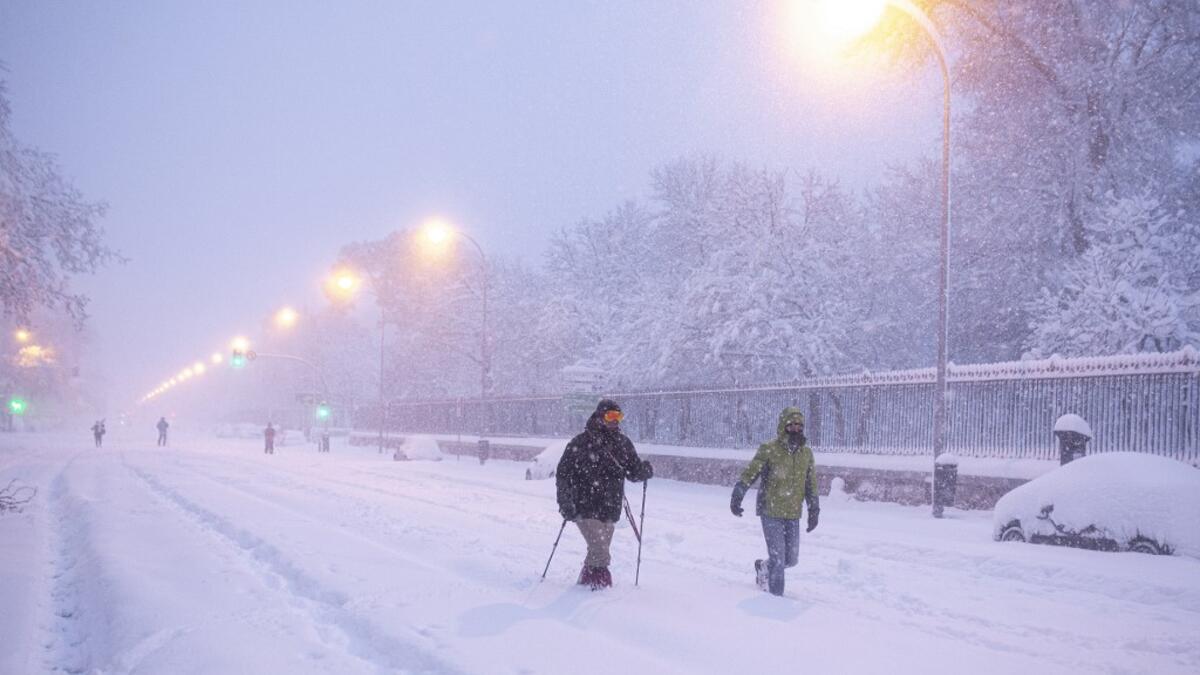 People walk amid a heavy snowfall in Madrid on January 9, 2021. Heavy snow fell across much of Spain, leaving huge areas blanketed in white as Storm Filomena brought wintry weather not seen in decades to the Iberian peninsula. Benjamin Cremel / AFP