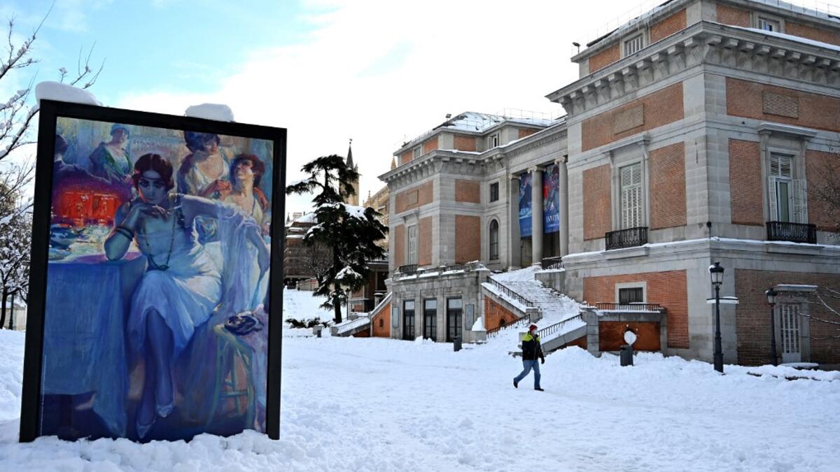 A man walks past the Prado Museum in Madrid on January 10, 2021. Snowstorms in Spain left three people dead and caused chaos across much of the country, trapping motorists and shutting down the capital's air and rail links. Gabriel BOUYS / AFP