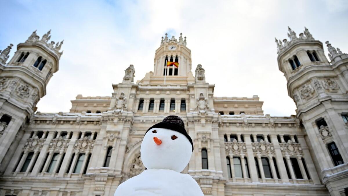 A snowman is built outside the Cibeles Palace in Madrid on January 10, 2021. Snowstorms in Spain left three people dead and caused chaos across much of the country, trapping motorists and shutting down the capital's air and rail links. Gabriel BOUYS / AFP