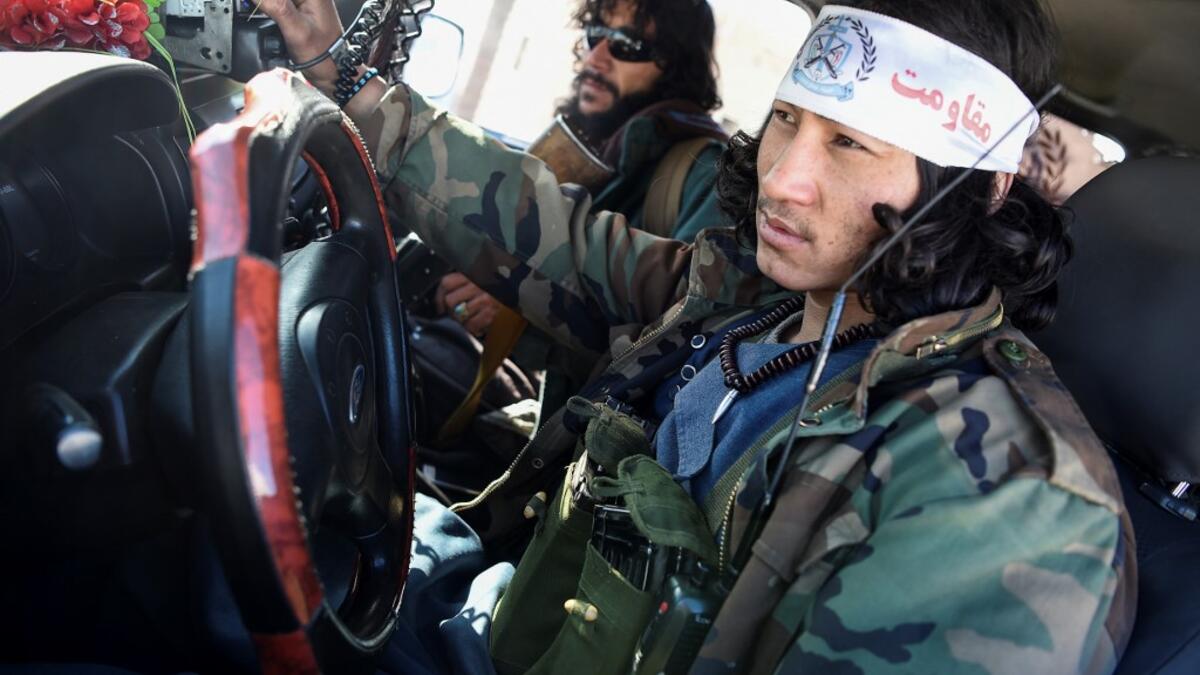In this photo taken on January 9, 2021, Hazara armed militia for the Resistance for Justice Movement, sit in a car in front of their base during a patrol against Taliban insurgents at Hisa-e-Awali Behsud district of Maidan Wardak Province. Comprising roughly 10 to 20 percent of Afghanistan's 38-million population, Hazaras have long been persecuted for their largely Shiite faith by Sunni hardliners in a country wracked by deep ethnic divisions. WAKIL KOHSAR / AFP