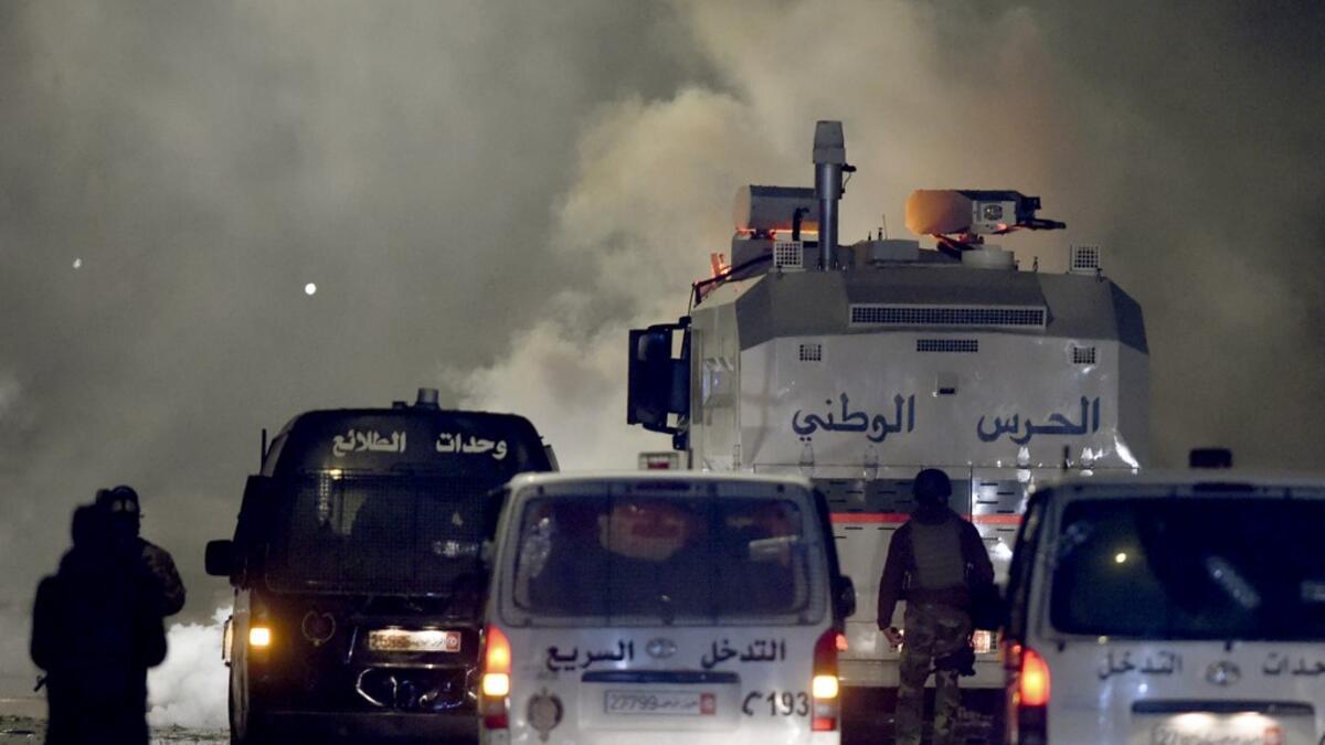 Tunisian security forces gather as protesters block a street in the Ettadhamen city suburb on the northwestern outskirts of Tunis on January 18, 2021, amidst a wave of nightly protests in the North African country. The social unrest comes at a time of economic crisis, worsened by the pandemic, that has sparked rapid inflation and high youth unemployment and led many people to leave Tunisia. FETHI BELAID / AFP
