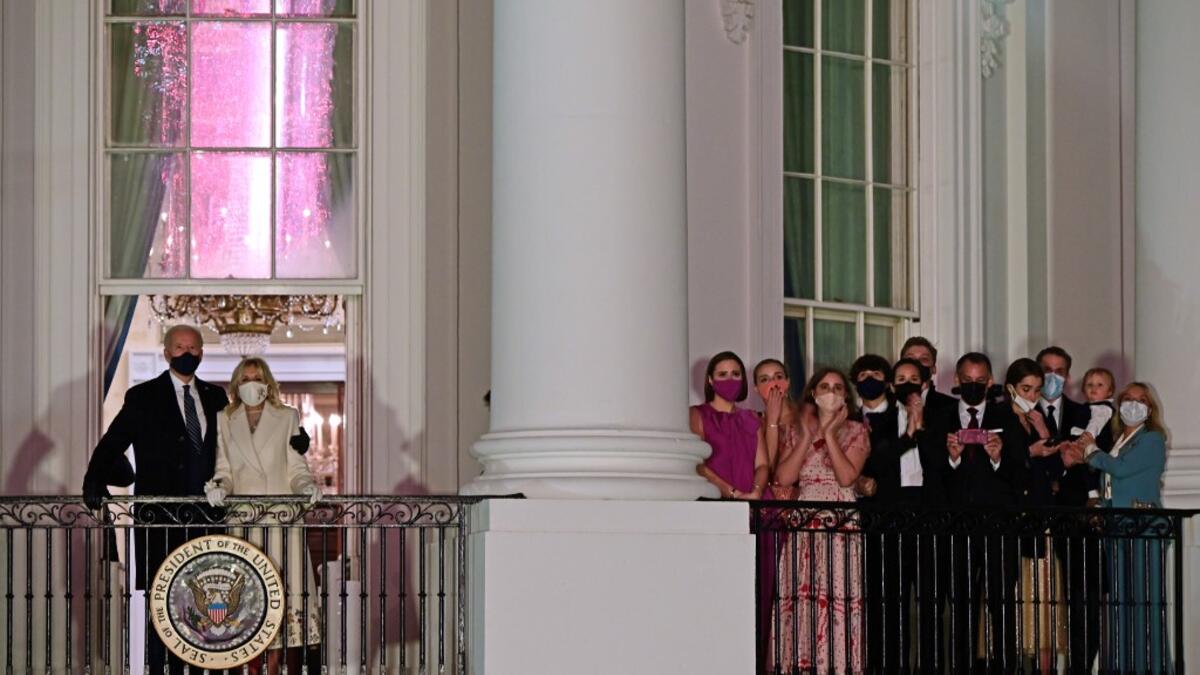US President Joe Biden (L) and First Lady Jill Biden (2nd L) appear on the Blue Room Balcony as they and family members (R) watch fireworks from the White House in Washington, DC on January 20, 2021. JIM WATSON / AFP