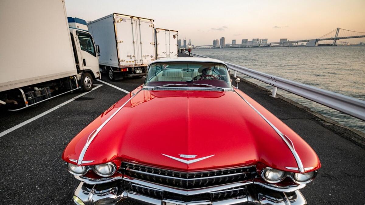 This picture taken on January 16, 2021 shows Hiroyuki Wada, who runs a vintage car service company, sitting in a 1959 Cadillac Coupe DeVille after a gathering of auto enthusiasts in Tokyo. A loose club of fans rolls up most weekends in central Tokyo to show off their Cadillacs, Chevrolets and other modern classic vehicles from the mid to late 20th century. Philip FONG / AFP
