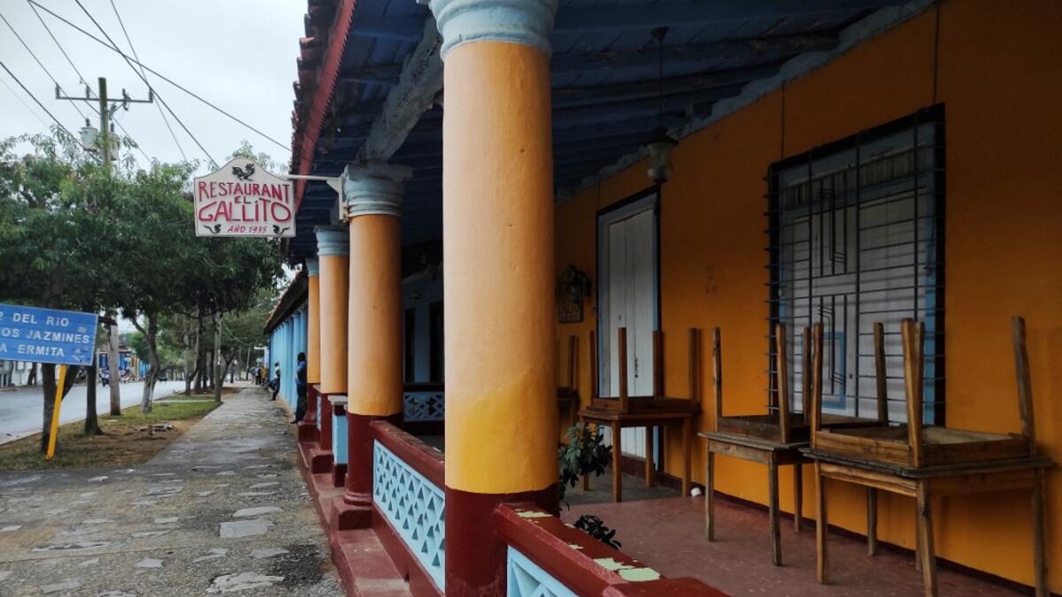 A man walks by a closed private restaurant in Vinales, Cuba, on January 28, 2021. At the foot of the majestic rock formations of Vinales, the terraces of the restaurants look empty and the lodgings have closed. With the arrival of COVID-19, the incipient prosperity of this Cuban town came to a halt and people abandoned tourism jobs to return to work the land. YAMIL LAGE / AFP