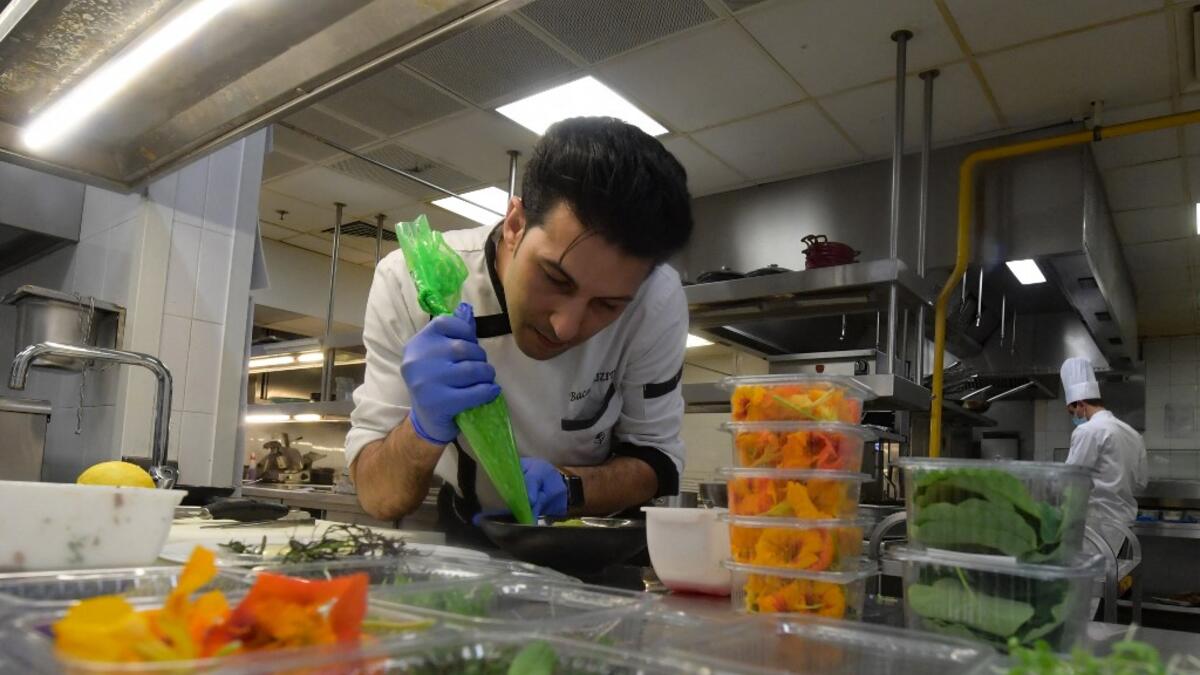 Tunisian chef Bassem Bizid uses edible flowers to prepare his dishes at a luxury hotel in Gammarth, an upscale northern suburb of the capital Tunis, on February 5, 2021. Tunisians already use certain flowers in their traditional cuisine. Some sweets feature dried rose petals, while lavender is an ingredient in a spice mix used in couscous recipes. But fresh flowers, which can be used for dishes from soups to salads as well as teas, are a novelty.  FETHI BELAID / AFP
