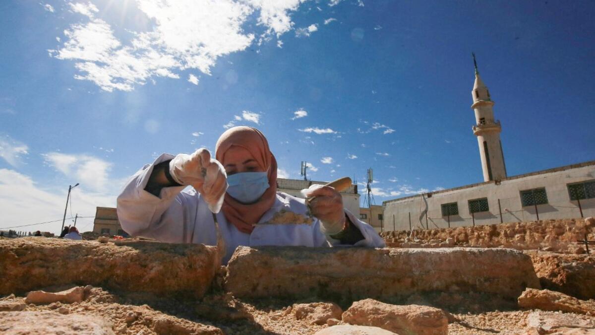 A worker employed by a pilot project run by the UN cultural agency UNESCO, restores a stone wall at an ancient church complex, in the small town of Rihab, some 70 kilometres north of the Jordanian capital Amman, on February 9, 2021. In the ruins of the ancient Byzantine church in Jordan, local townspeople and Syrian refugees work side by side on a project that unites preserving cultural heritage and fighting poverty.  Khalil MAZRAAWI / afp