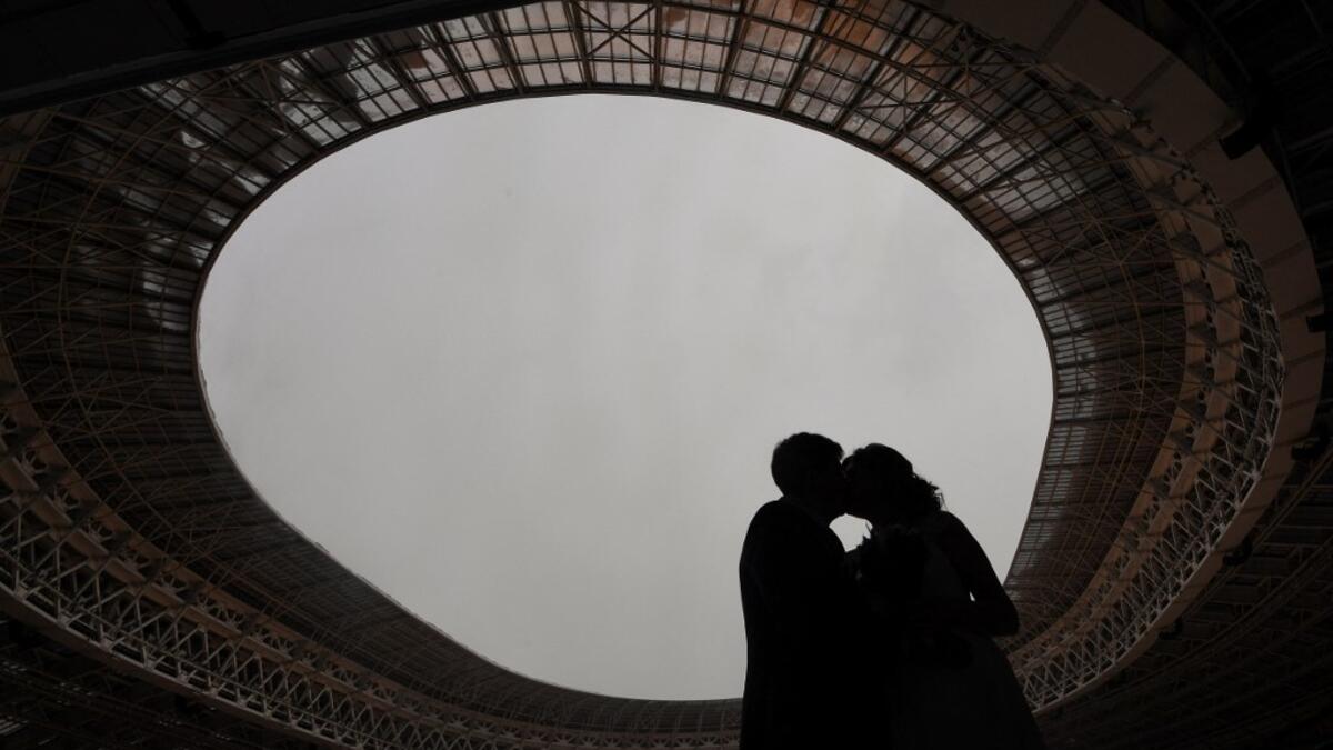 Newlyweds kiss during their wedding ceremony at the Luzhniki stadium in Moscow on February 12, 2021, days before Valentine's Day. NATALIA KOLESNIKOVA / AFP