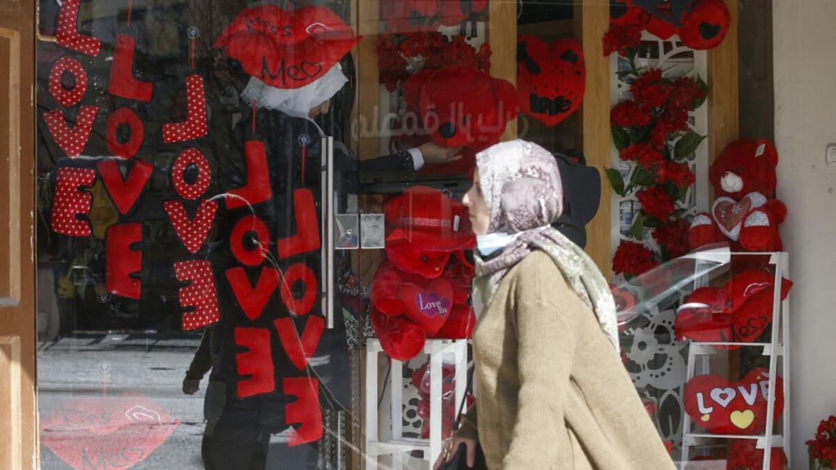 A Palestinian shopkeeper arranges gifts in a window on the eve of Valentine's Day at a shop in Hebron city, in the occupied West Bank, on February 13, 2021. HAZEM BADER / AFP