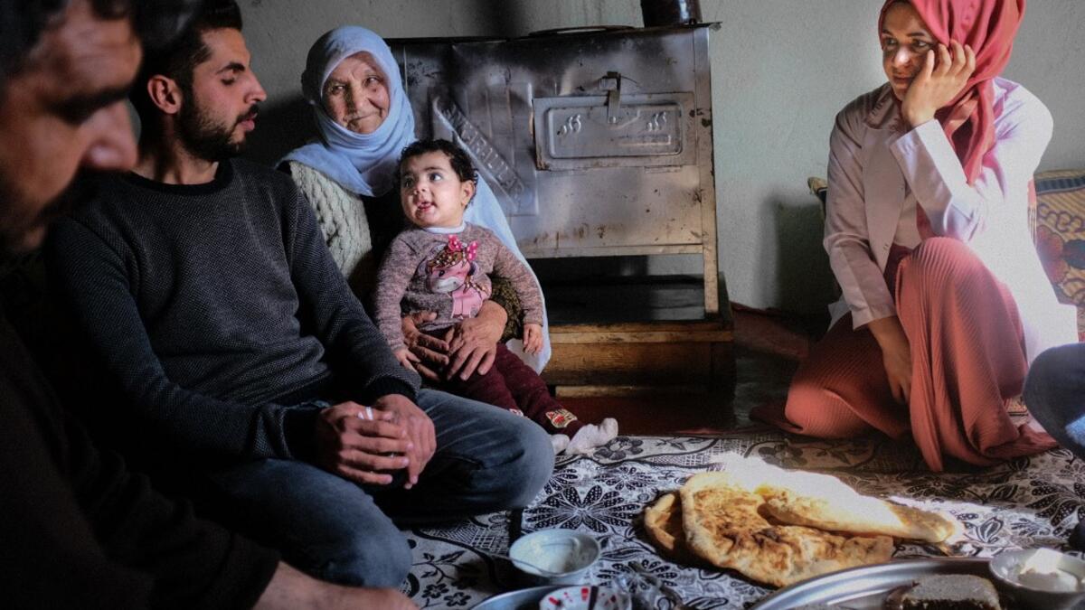 In this photograph taken on February 15, 2021, nurse Yildiz Ayten (R) from Bahcesaray public hospital vaccination team, enjoys her lunch offered by Kurdish inhabitant Zeri Saymaz (2nd-L) and her family after receiving her vaccine, at the village of Guneyyamac in eastern Turkey, as part of an expedition to vaccinate residents of 65 years old or above with Sinovac's CoronaVac Covid-19 vaccine. Turkey's population of more than 83 million is spread out across Europe and Asia and covers some seemingly impregnabl