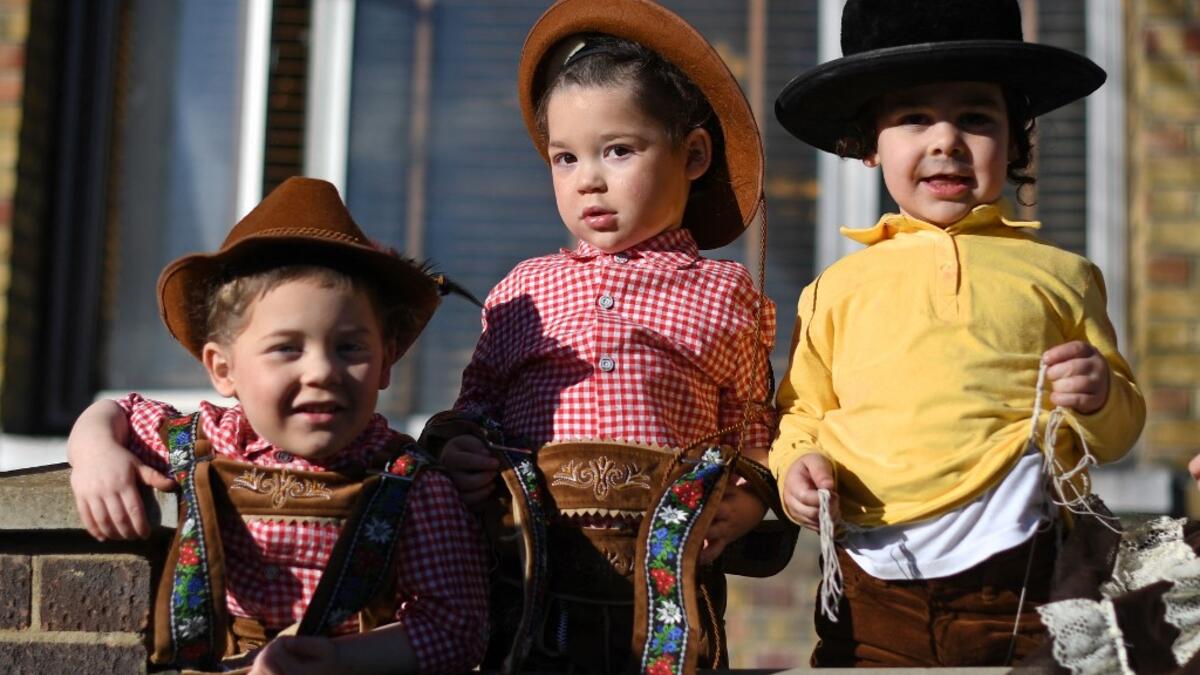 Young children dressed in costume in celebration of the Jewish holiday of Purim, pose for a photograph outside a house in the Orthodox Jewish neighborhood of Stamford Hill in north London on February 26, 2021. The carnival-like Purim holiday is celebrated with parades and costume parties to commemorate the deliverance of the Jewish people from a plot to exterminate them in the ancient Persian Empire 2,500 years ago, as recorded in the Biblical Book of Esther. DANIEL LEAL-OLIVAS / AFP