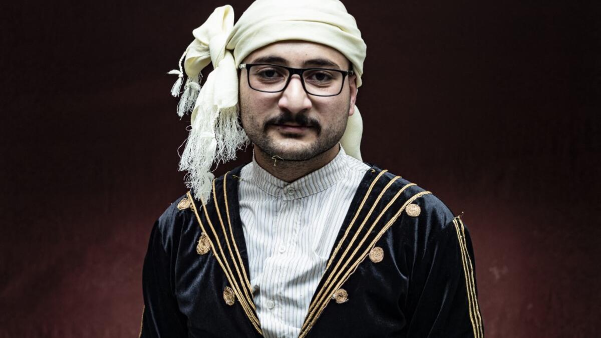 A Syrian Kurdish man in traditional attire poses for a picture