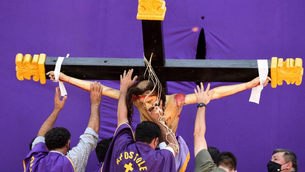 Catholic faithful reenact the Way of the Cross during Good Friday in Capiata