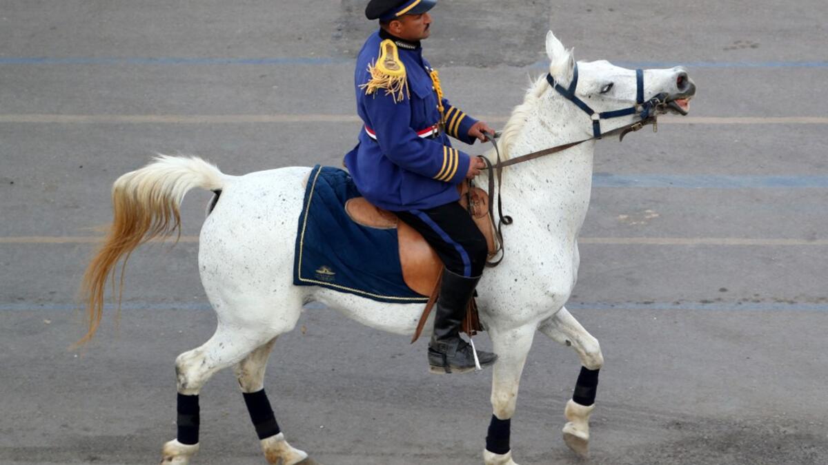 A mounted policeman dressed in ceremonial uniform rides along the parade area before the start of the parade of 22 ancient Egyptian royal mummies