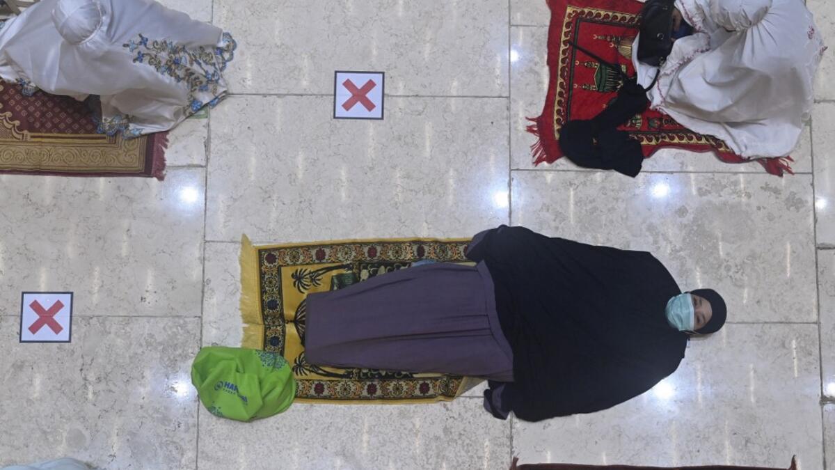 A woman rests prior to night prayers on the first day of Ramadan at the Istiqlal grand mosque in Jakarta