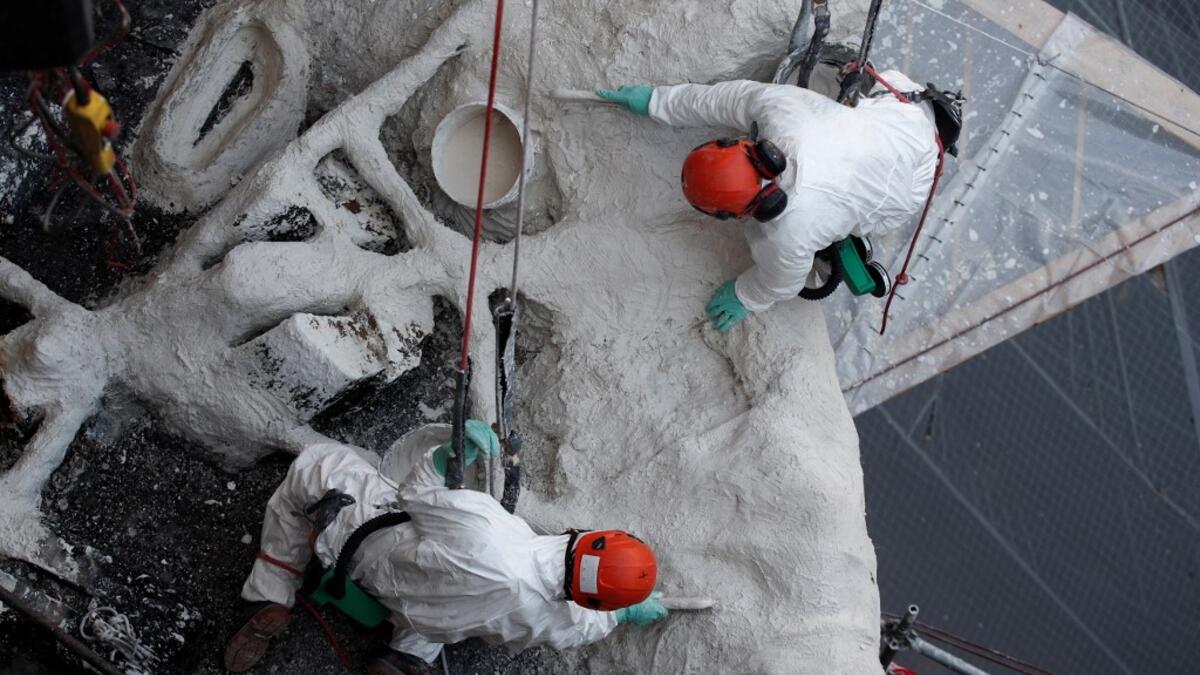 Rope access technicians work on a damaged vault of the Notre-Dame de Paris Cathedral