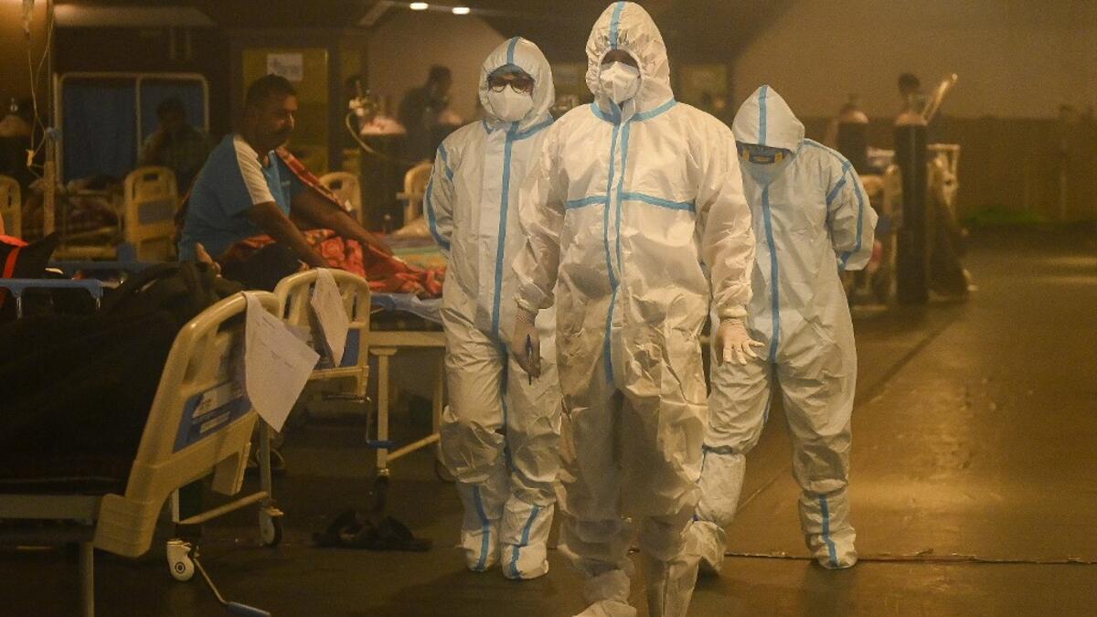 Health workers wearing personal protective equipment (PPE kit) attends to Covid-19 coronavirus positive patients inside a banquet hall