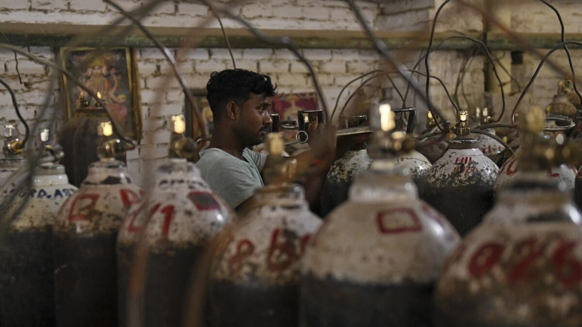 Workers are seen sorting oxygen cylinders that are being used for Covid-19 coronavirus patients