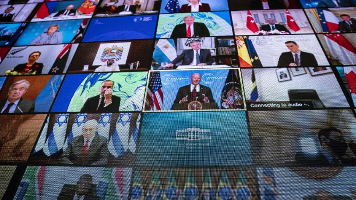 World leaders are seen remotely on a screen as U.S. President Joe Biden delivers remarks during a virtual Leaders Summit on Climate with 40 world leaders in the East Room of the White House