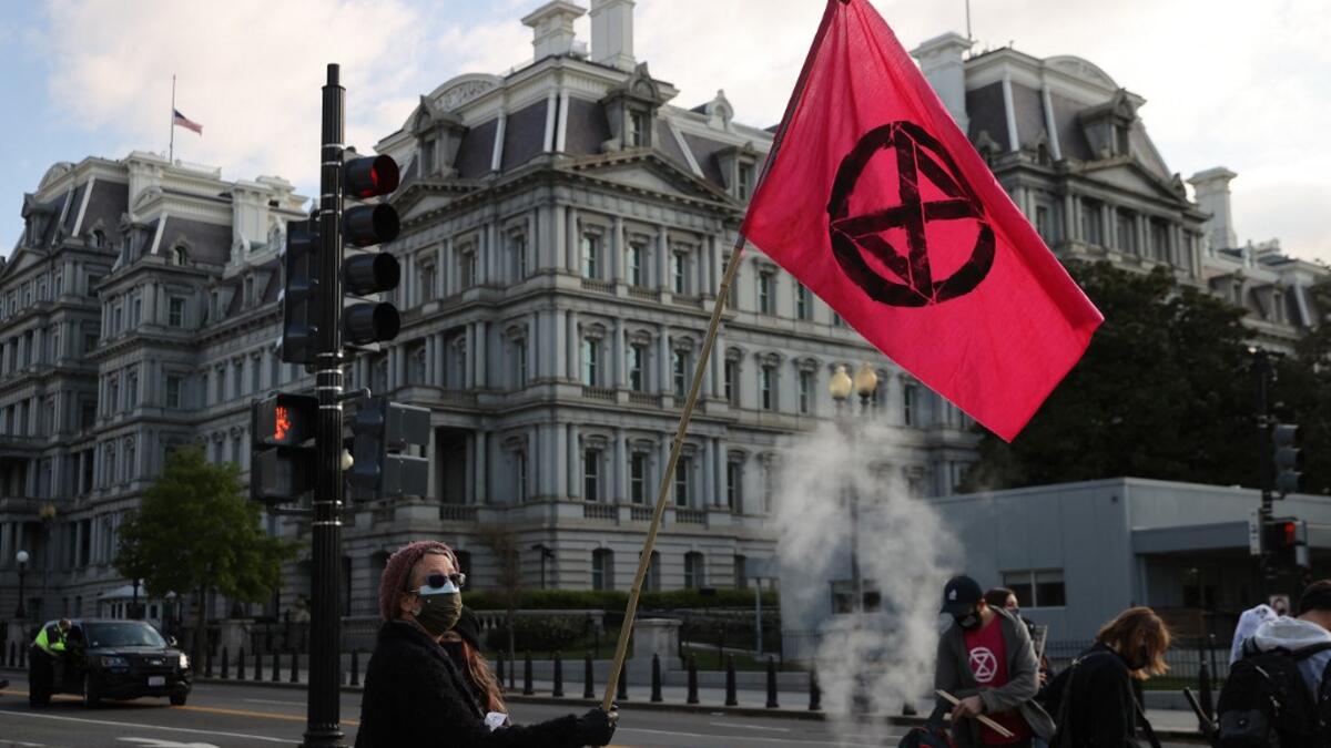 WASHINGTON, DC - APRIL 22: Activists halt traffic outside the White House while protesting against President Joe Biden's climate change policy on Earth Day, April 22, 2021 in Washington, DC. Organized by the Extinction Rebellion DC, protesters used bright pink wheelbarrows to dump heaps of cow manure at the intersection of New York Avenue and 17th Street NW on the west side of the White House campus. Despite the White House hosting a virtual Leaders Summit on Climate on Earth Day