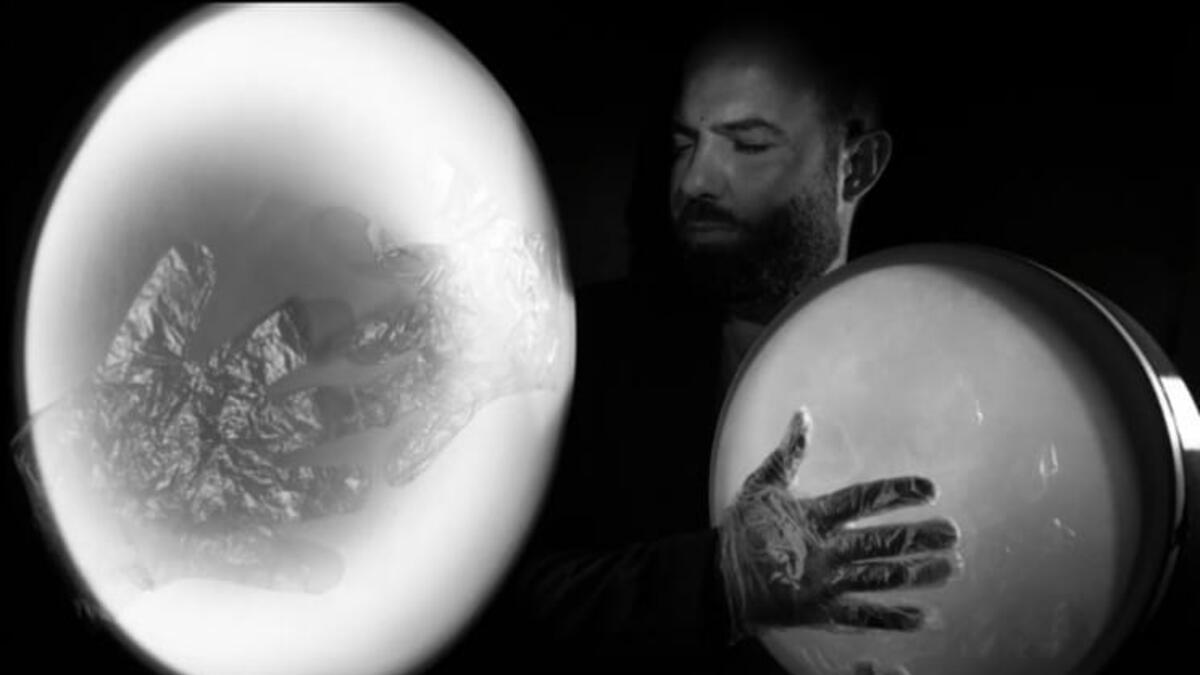 A musician in foil gloves is playing an instrument