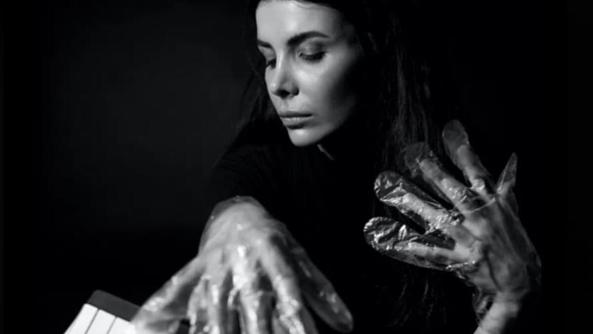 A musician in foil gloves is playing an instrument