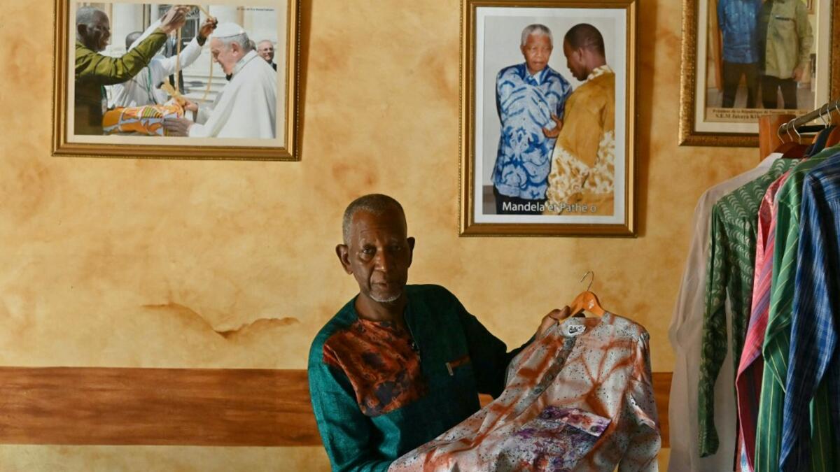 Ivorian-Burkinabe fashion designer Pathé Ouedraogo, known as Pathé'O, poses for a photograph in his store in Abidjan on May 26, 2021. A small self-taught tailor in his early years, the Ivorian-Burkinabe Pathe'O became the designer of African heads of state and celebrates the fiftieth anniversary of his brand, leading the "fight" for the recognition of fashion on the continent
