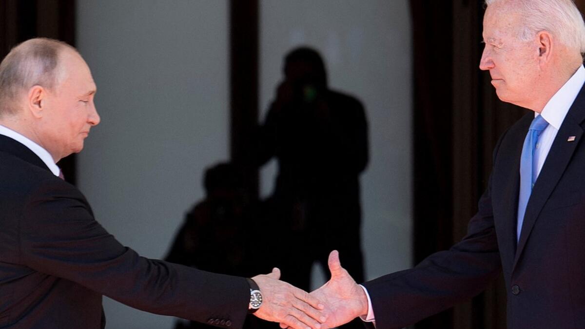 Russian President Vladimir Putin (L) shake hands with US President Joe Biden prior to the US-Russia summit at the Villa La Grange, in Geneva