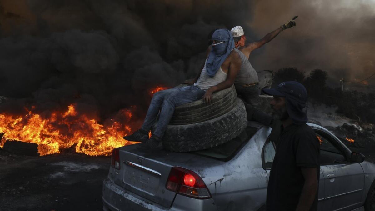 Palestinians burn tires during a night demonstration against the expansion of the Jewish settlement outpost of Eviatar on the lands of Beita village, near the occupied West Bank city of Nablus