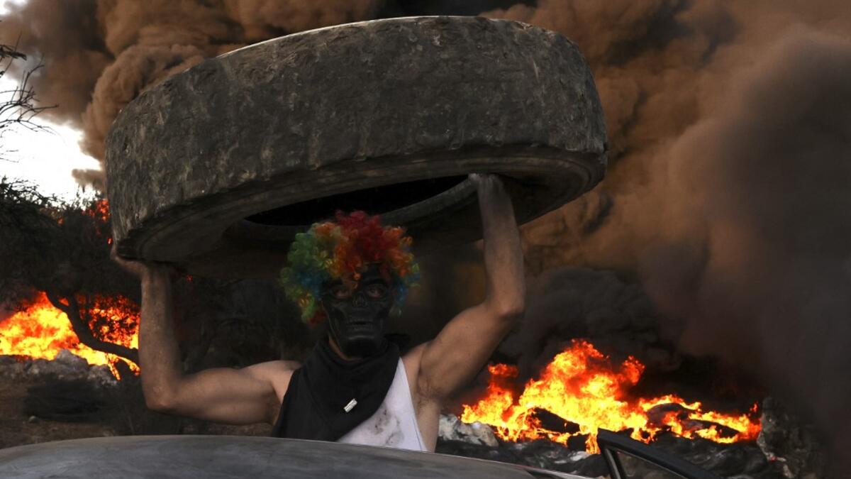 Palestinians burn tires during a night demonstration against the expansion of the Jewish settlement outpost of Eviatar on the lands of Beita village, near the occupied West Bank city of Nablus
