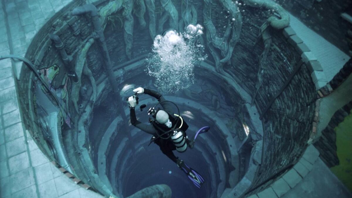 A diver experiences Deep Dive Dubai, the deepest swimming pool in the world reaching 60m, in the United Arab Emirates, on July 10, 2021. The city of superlatives, with the world's tallest tower among its many records, Dubai now has the deepest swimming pool on the planet complete with a "sunken city" for divers to explore. GIUSEPPE CACACE / AFP
