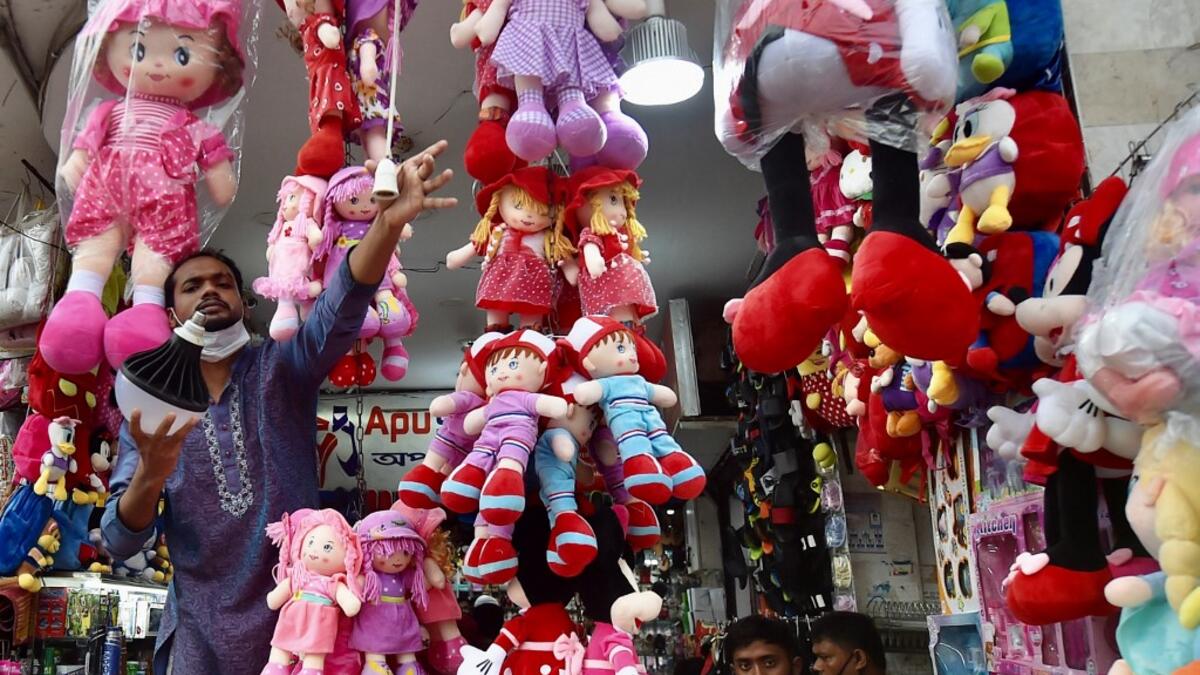 A shopkeeper installs a lightbulb outside his shop waiting for customers to shop after the government loosened a lockdown imposed as a preventive measure against the Covid-19 coronavirus ahead of the Muslim festival of Eid al-Adha in Dhaka on July 16, 2021. Munir Uz zaman / AFP