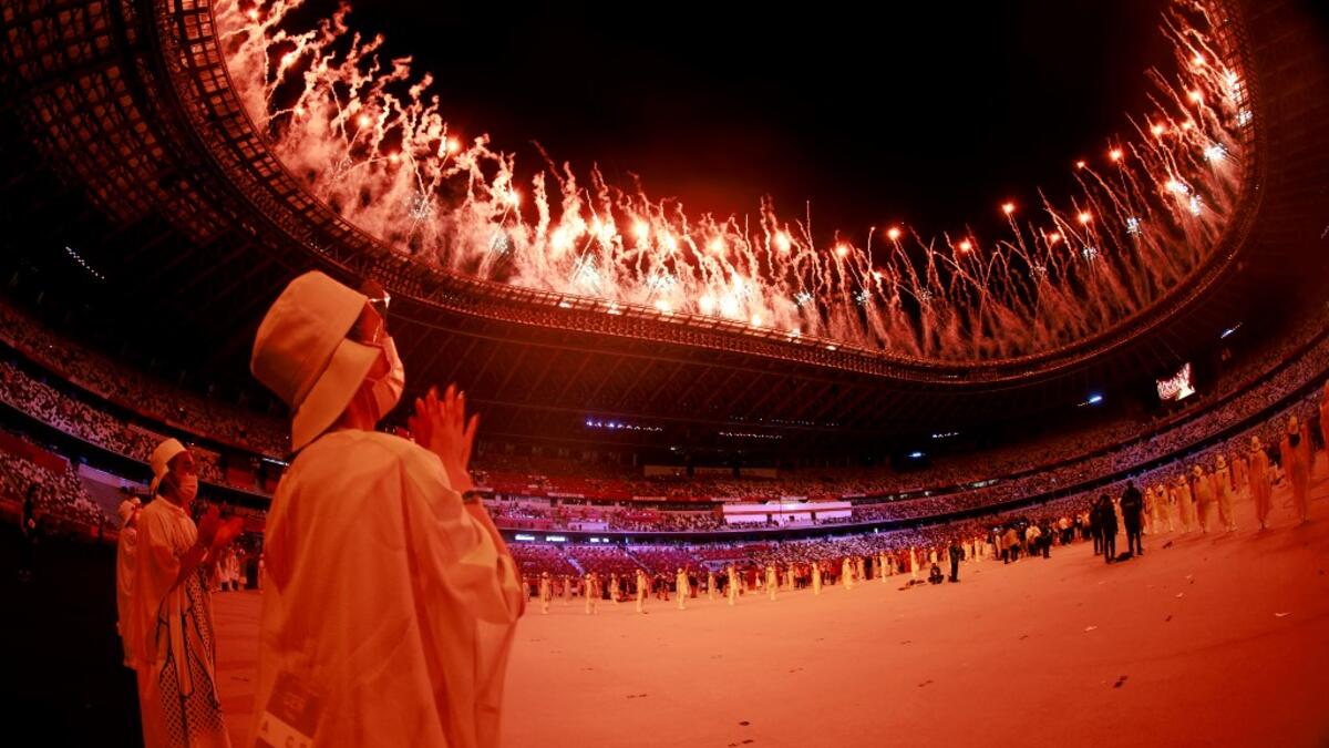 A volunteer reacts during a fireworks display at the end of the opening ceremony of the Tokyo 2020 Olympic Games, at the Olympic Stadium, in Tokyo