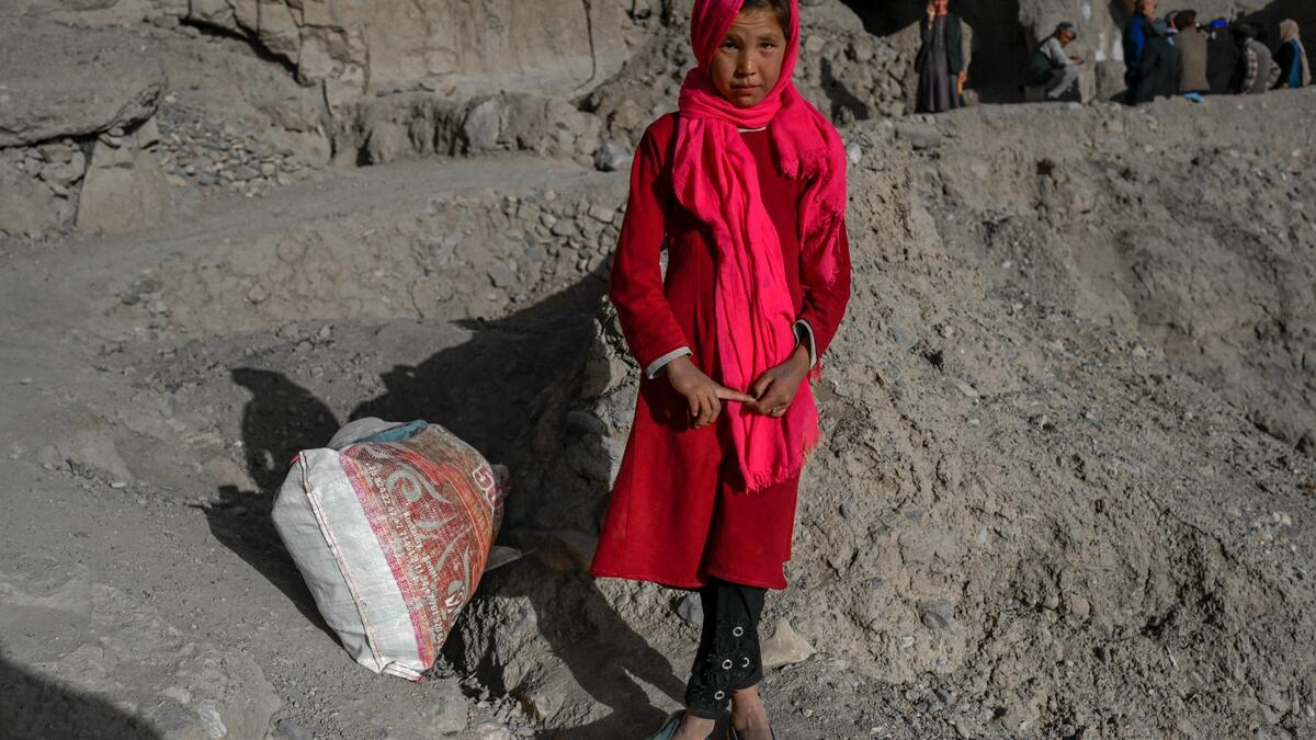 In this picture taken on October 3, 2021, a Hazara ethnic girl stands near a cliff pockmarked by caves where people still live as they did centuries ago in Bamiyan.