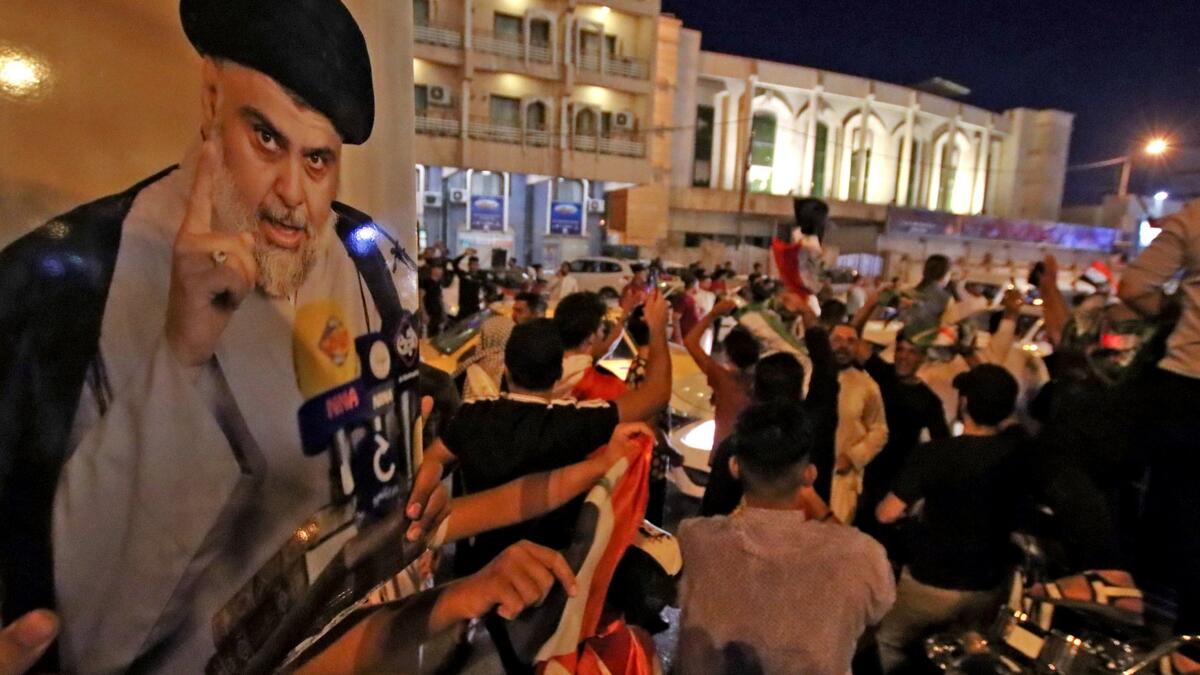 Supporters of Iraqi Shiite cleric Muqtada al-Sadr ride in vehicles while celebrating in the central shrine city of Najaf after the closure of polls during the early parliamentary elections on October 10, 2021. (Photo by Ali NAJAFI / AFP)