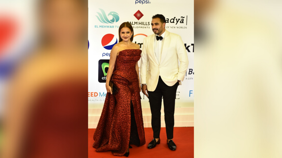 Egyptian actress Nelly Karim (L) and her husband pose on the red carpet during the opening of the 43rd edition of the Cairo International Film Festival (CIFF) at the Cairo Opera House in the Egyptian capital on November 26, 2021. (Photo by Sayed HASAN / AFP)