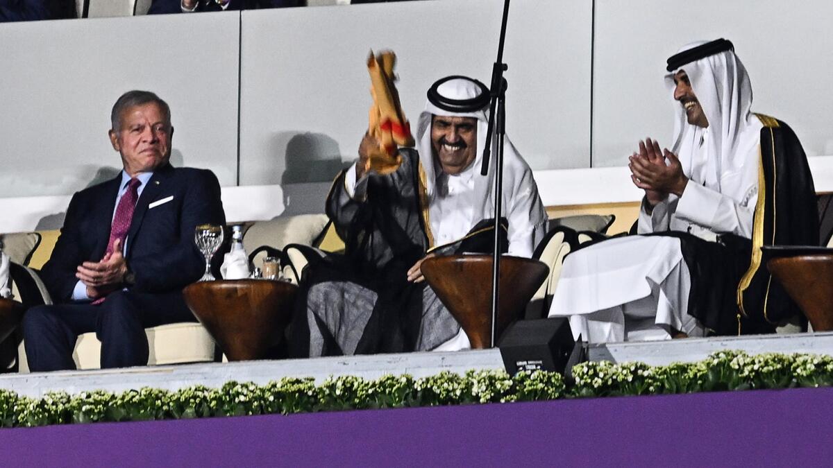 Qatar's former Emir Sheikh Hamad bin Khalifa al-Thani (2ndL) and Qatar's Emir Sheikh Tamim bin Hamad al-Thani waves a signed Qatari jersey next to Qatar's Emir Sheikh Tamim bin Hamad al-Thani (R) and Abdullah II King of Jordan (L) during the opening ceremony ahead of the Qatar 2022 World Cup