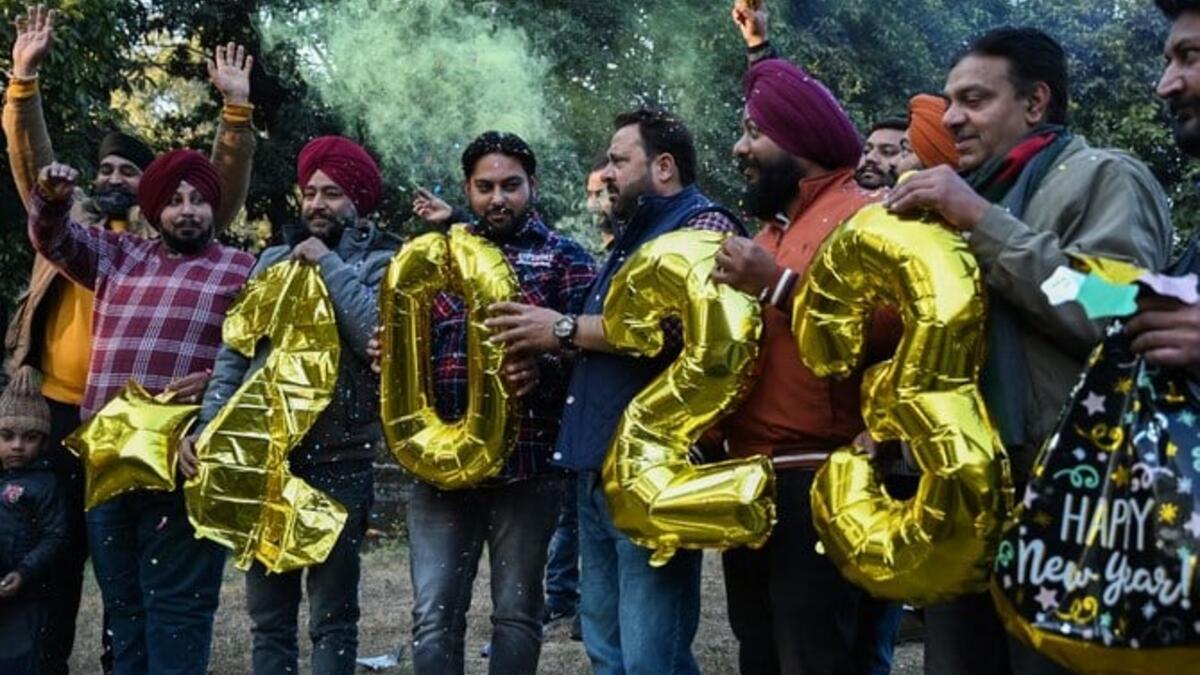 أشخاص يحملون بالونات على شكل أرقام خلال الاحتفالات عشية رأس السنة الجديدة في أمريتسار عاصمة ولاية البنجاب، 31 ديسمبر 2022 (أ ف ب)