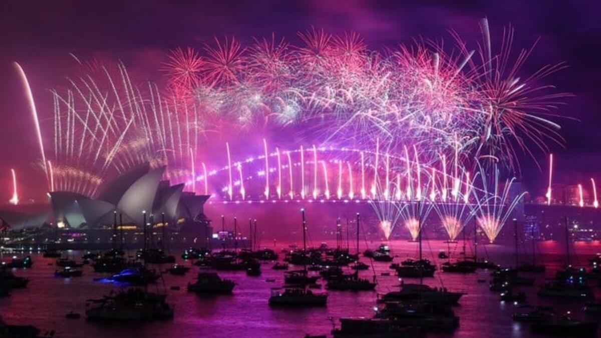 الألعاب النارية ليلة رأس السنة الجديدة تضيء السماء فوق دار أوبرا سيدني (على اليسار) وجسر هاربور خلال عرض الألعاب النارية في سيدني. (أ ف ب)