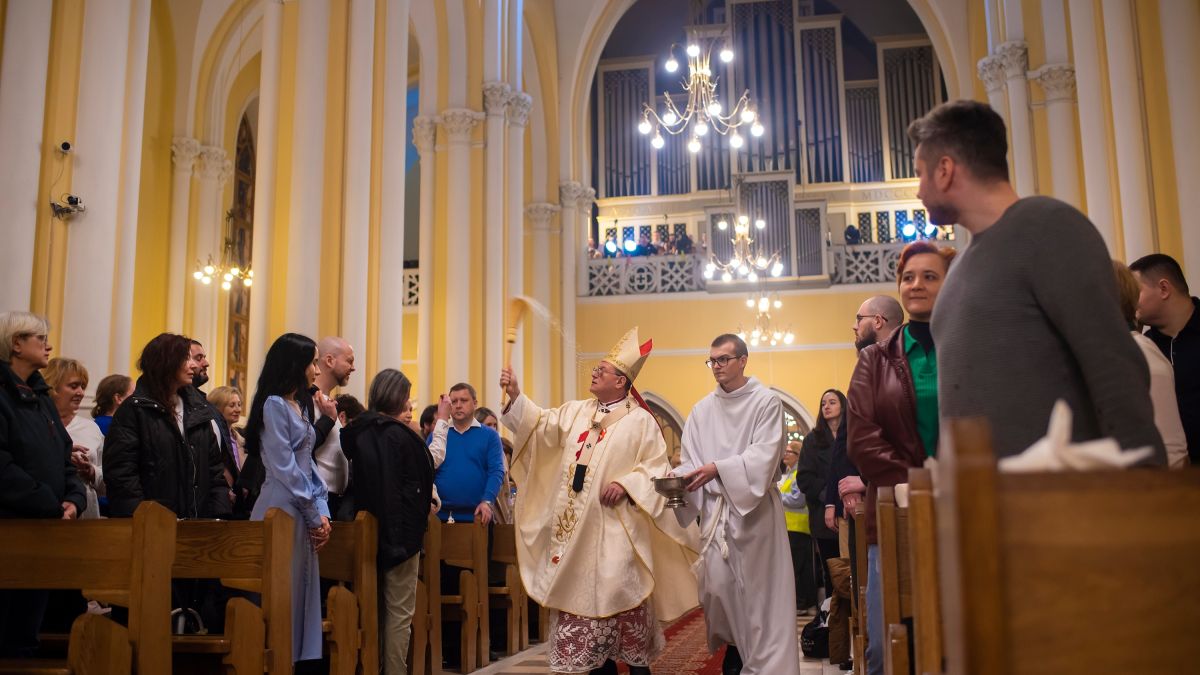 موسكو، روسيا. ليلة 30 إلى 31 مارس 2024. عيد القيامة في كاتدرائية كاثوليكية. يقوم الأسقف برشّ الناس بالماء المقدس.