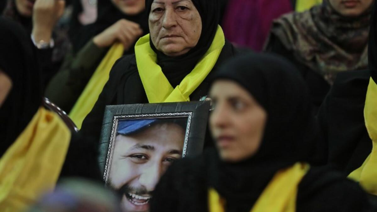 A Lebanese woman carries a portrait of her dead son as she attends a gathering for a televised speech held by the Shiite party in the capital Beirut, commemorating the party's killed leaders, on Feb. 16, 2018. 
(JOSEPH EID / AFP)