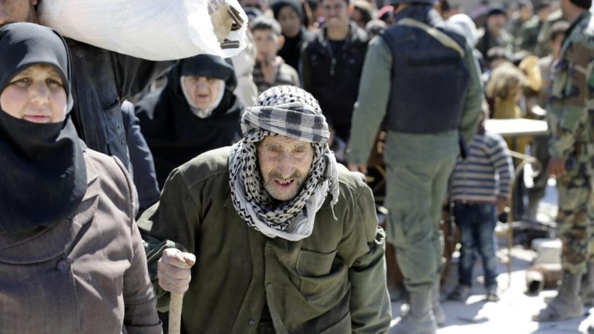 Syrian civilians, evacuated from rebel-held areas in the Eastern Ghouta, gather at a school in the regime-controlled Hosh Nasri, on the northeastern outskirts of the capital Damascus on Mar.16, 2018, ahead of being relocated to other areas. (LOUAI BESHARA / AFP)