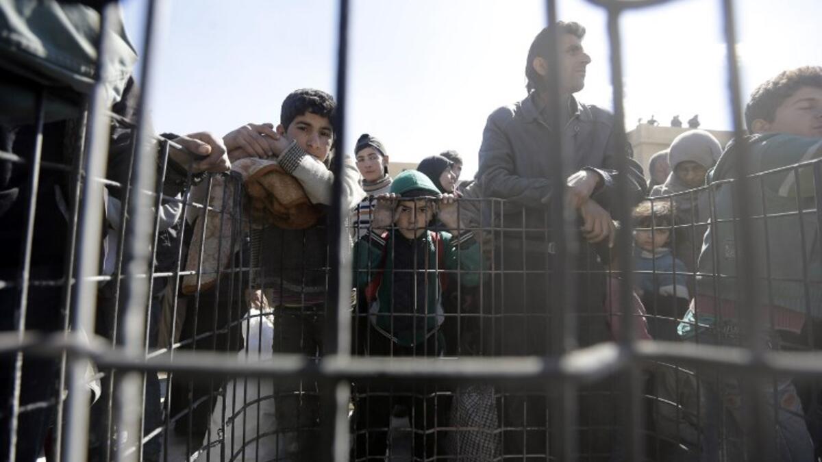 Syrian civilians, evacuated from rebel-held areas in the Eastern Ghouta, gather at a school in the regime-controlled Hosh Nasri, on the northeastern outskirts of the capital Damascus on Mar.16, 2018, ahead of being relocated to other areas. (LOUAI BESHARA / AFP)