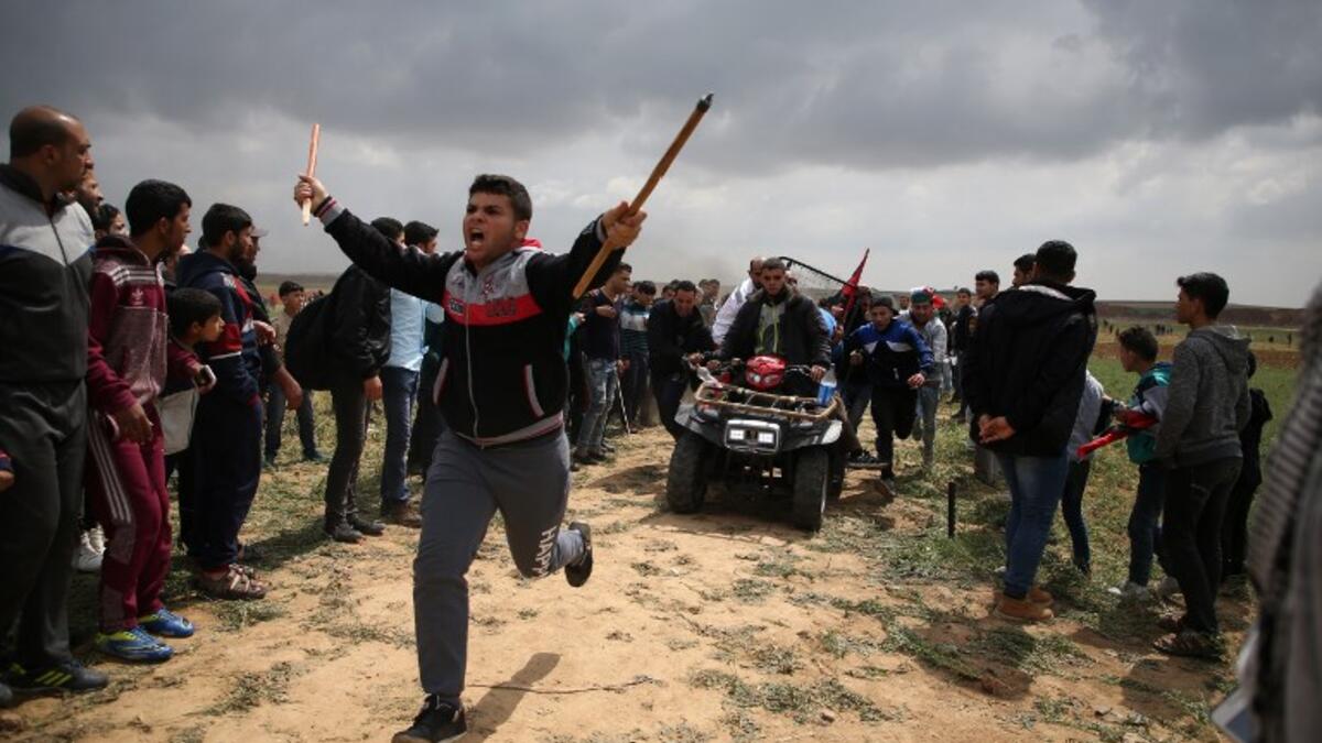 A picture taken on Mar. 30, 2018 shows a Palestinian youth being carried on an all-terrain vehicle after being injured during a demonstration near the border with Israel east of Jabalia in the Gaza strip commemorating Land Day. (MOHAMMED ABED / AFP)