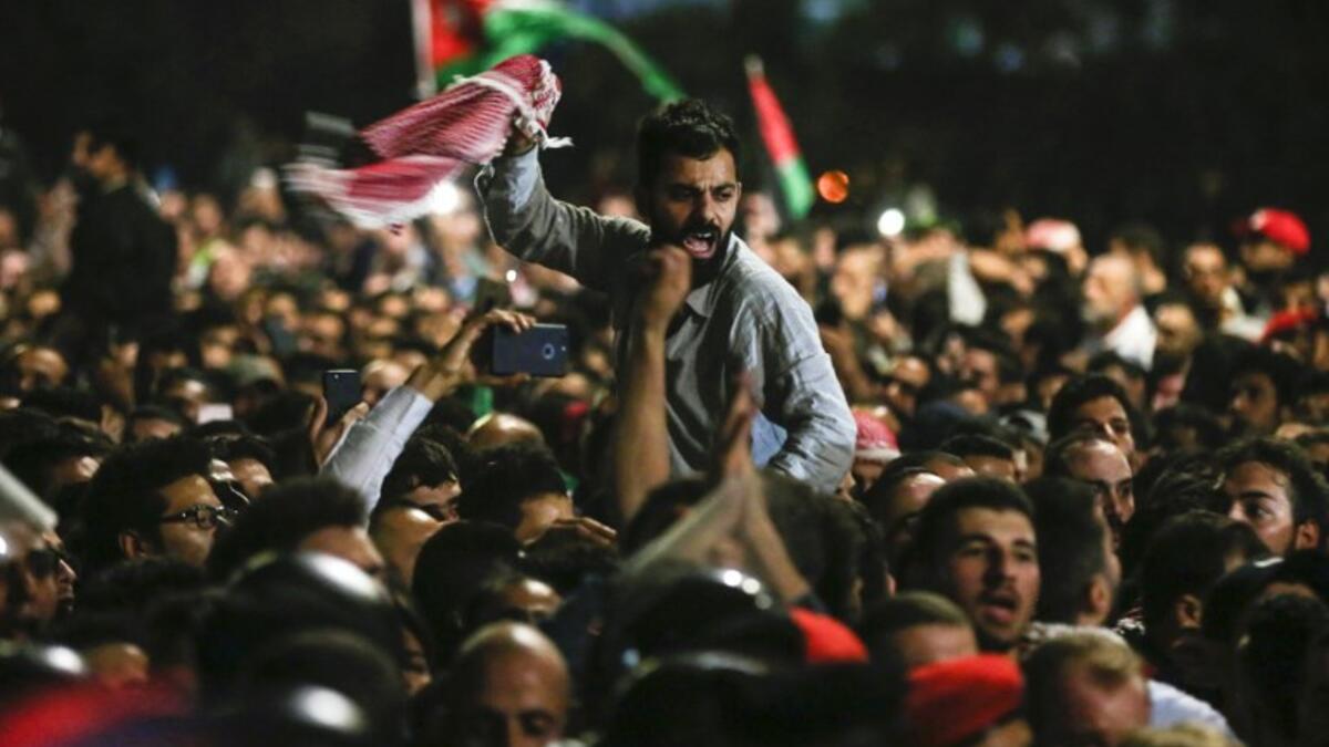 Jordanian protesters shout slogans and raise a national flag during a demonstration outside the Prime Minister's office in the capital Amman late on June 2, 2018. 
Khalil MAZRAAWI / AFP