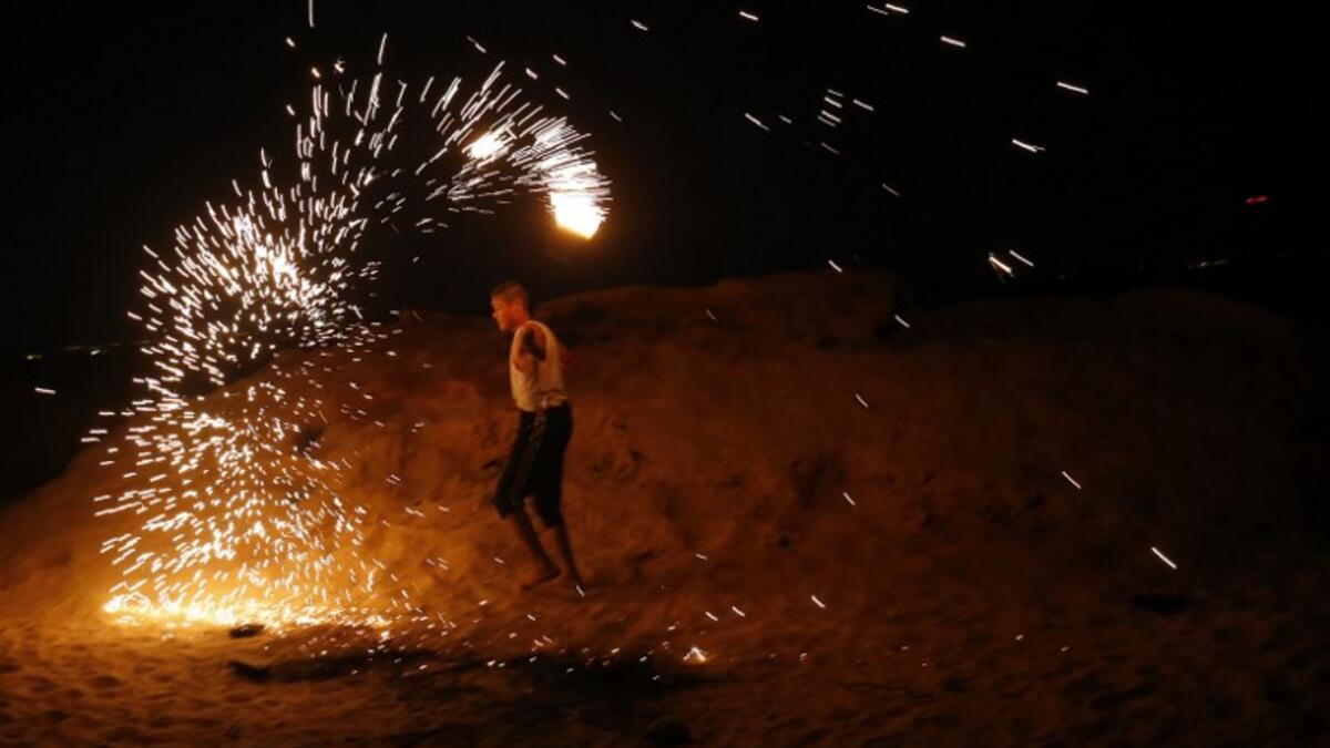 A Palestinian protester from a group calling themselves the "night confusion units" waves a sparkler near the Gaza-Israel border east of Rafah in the southern Gaza Strip, on September 26, 2018. 
SAID KHATIB / AFP