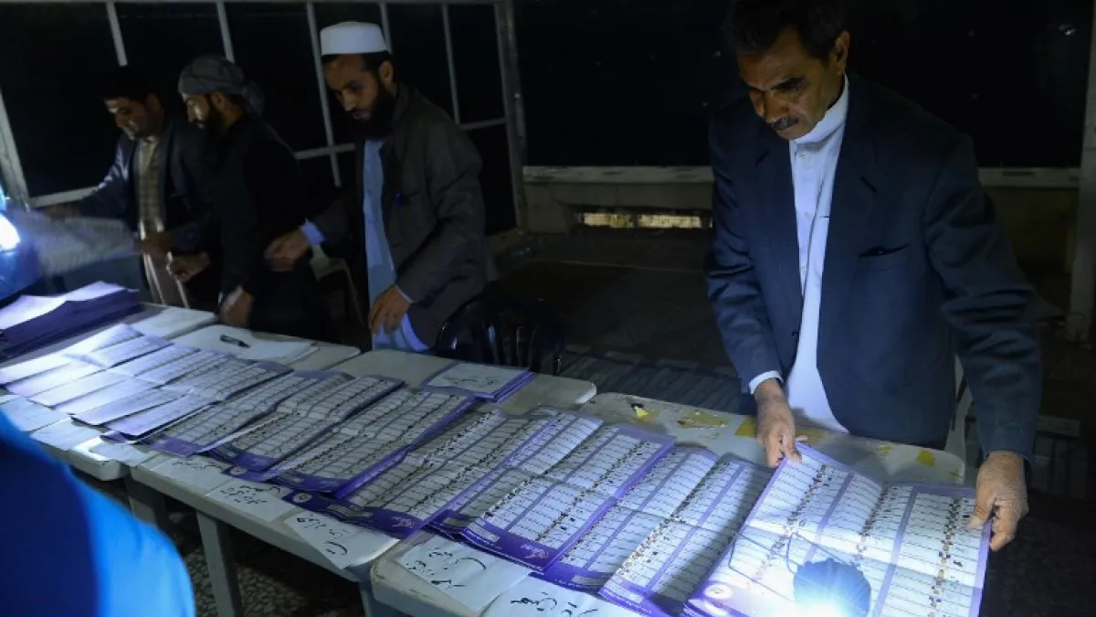 In this photo taken on October 20, 2018, Afghan Independent Election Commission (IEC) officials count ballot papers at a polling centre for the country's legislative election in Herat province. 
HOSHANG HASHIMI / AFP